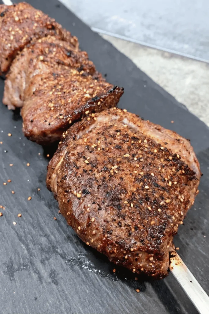 Rotisserie Picanha Steak – Juicy Brazilian Beef Recipe 5 Grilled picanha steaks skewered and ready for rotisserie